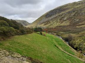 A green hill with trees and a river

AI-generated content may be incorrect.